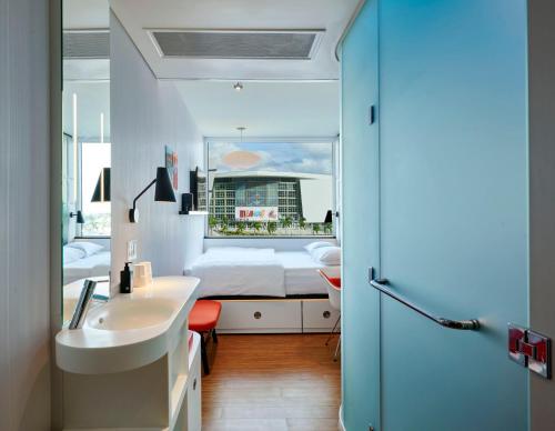 迈阿密citizenM Miami Worldcenter的一间带水槽的浴室和一张位于客房内的床