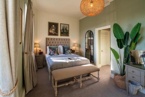 伯福德Prince of Burford的一间卧室配有一张床和盆栽植物