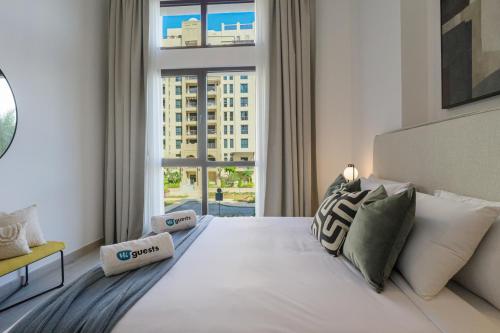 迪拜HiGuests - Charming Modern Apartment Close To The Souk in MJL的卧室设有一张大白色的床和大窗户