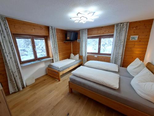 因斯布鲁克Apartmenthaus PARADISE的一间卧室设有两张床和两个窗户。