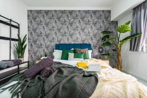 八打灵再也Kelana Puteri by JustStay 7mins walking to Paradigm Mall的一间卧室配有一张大床,提供紫色和绿色枕头