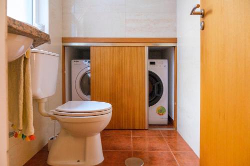 英雄港Cantinho do Cantagalo的一间带卫生间、洗衣机和烘干机的浴室