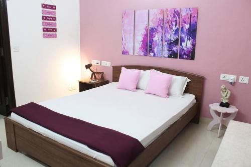 新德里Luxurious modern 2BHK prime location Delhi (13)的一间卧室配有带粉色和白色枕头的床