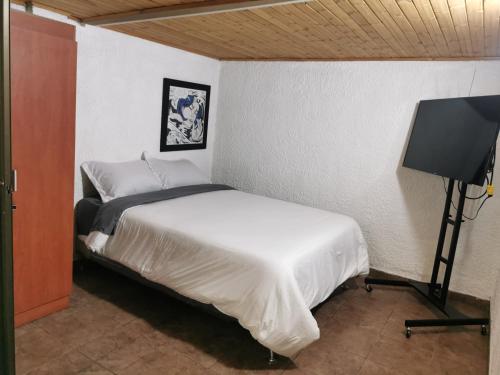 波哥大Portal Norte 170 ACOGEDORAS HABITACIONES CON TODOS LOS SERVICIOS的一间卧室配有一张床和一台平面电视