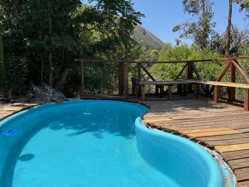 圣地亚哥Alojamiento en San José de Maipo的木甲板旁的游泳池,配有野餐桌