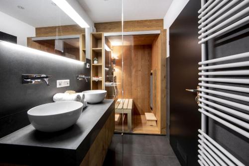 费尔德伯格Penthouse Feldberg的浴室设有黑色柜台上的两个盥洗盆
