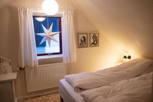 瑟沃格Cosy old house Vágar next to Mykines的一间卧室配有一张床,窗户上有一星星