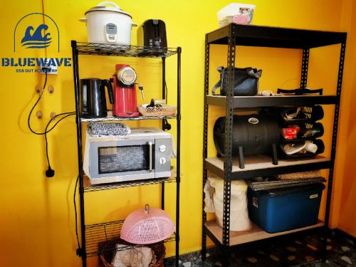 瓜埠Bluewave Sea Out Seaview Homestay的厨房配有微波炉和食品架