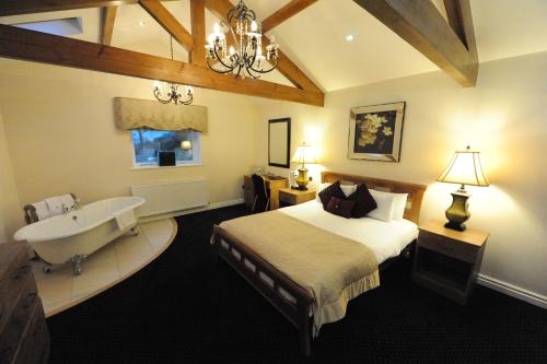 庞特佛雷特国王克罗夫特酒店的一间卧室配有一张床、一个浴缸和一个水槽