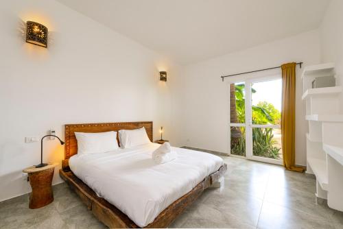 吉汶瓦Surfescape Zanzibar的一间卧室设有一张床和一个大窗户