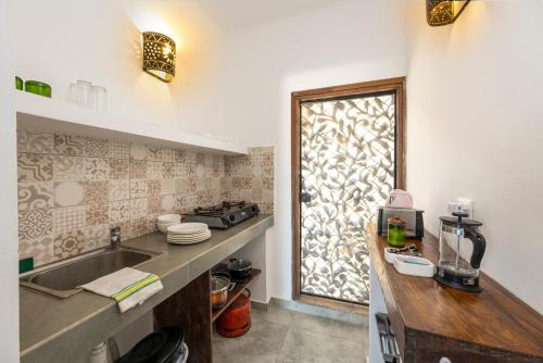 吉汶瓦Surfescape Zanzibar的厨房配有水槽和带窗户的台面