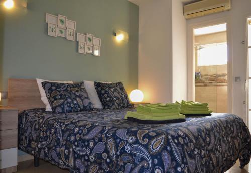 米哈斯科斯塔Matchroom Perla Roja 2的一间设有绿毛巾的床的房间