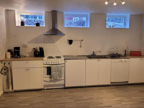 KulltorpBokskogens Guesthouse的厨房配有白色橱柜和炉灶烤箱。