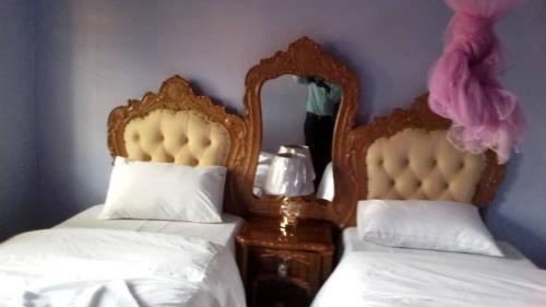 奇帕塔Faigib Guest House的一间卧室配有两张带白色床单和镜子的床