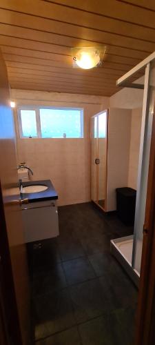GlaumbærHátún的客房内设有带水槽和浴缸的浴室