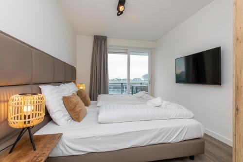 圣安娜兰Appartement Vista Maris, Havenweg 8-1, St. Annaland的一间卧室配有一张大床和电视