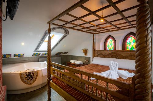 桑提亚纳德玛波萨达传奇酒店的一间卧室设有一张大床和一个浴缸