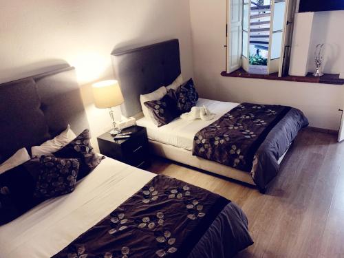 莫雷利亚M Hoteles Concepto的酒店客房设有两张床和窗户。