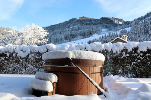 沙泰勒Chalet de montagne style savoyard, vue sur pistes的雪覆盖的热水浴池,带拖车