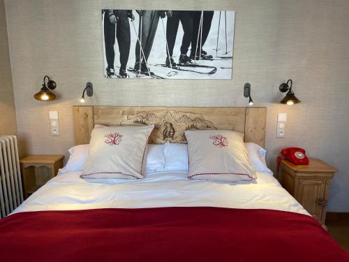 科特雷金狮大酒店的一张带两个枕头的床和一张墙上的照片