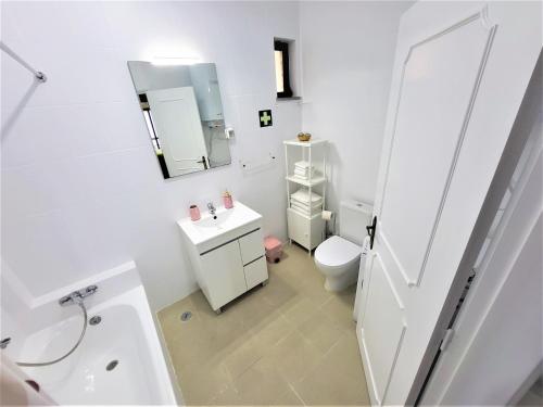 夫塞塔Apartamento Praia Fuzeta 2的白色的浴室设有卫生间和水槽。