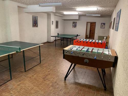 福波洛Piccolo Rifugio di Foppolo的一间设有乒乓球桌的房间,配有两张乒乓球桌