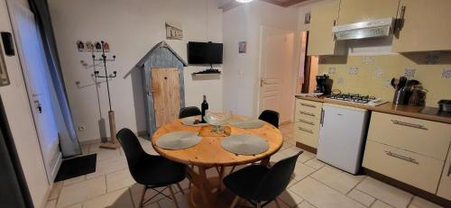 拉康提内勒Maisonette de pays classée 3 étoiles的厨房配有木桌和黑色椅子