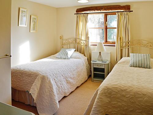 普利布里奇花园小屋酒店的一间卧室设有两张床和窗户。