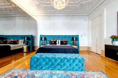 阿威罗1877 Estrela Palace的一间卧室配有蓝色的床和吊灯。