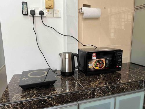 麻坡M Guest House2的厨房柜台配有微波炉和烤面包机。