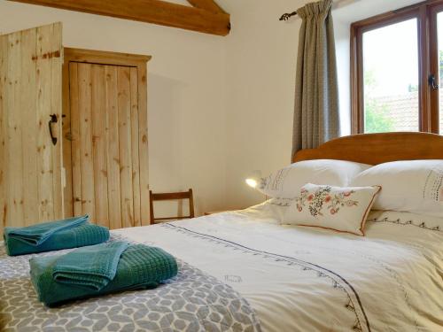 韦斯特尔顿The Wood Shed - E1919的一间卧室配有带白色床单和枕头的床。