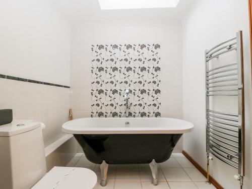 切普斯托The Granary的带浴缸和卫生间的浴室。