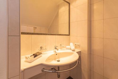 伊施格尔Hotel Garni Martina的白色的浴室设有水槽和镜子