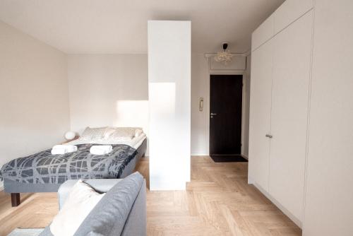 赫尔辛基2ndhomes Cozy high-quality Studio in Kluuvi with Balcony的白色卧室配有床和沙发