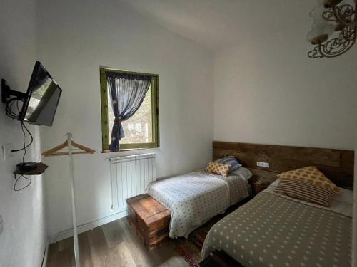 阿尔武希耶斯Stunning 4-Bed Cottage in Montseny Natural Park的一间卧室设有两张床和窗户。