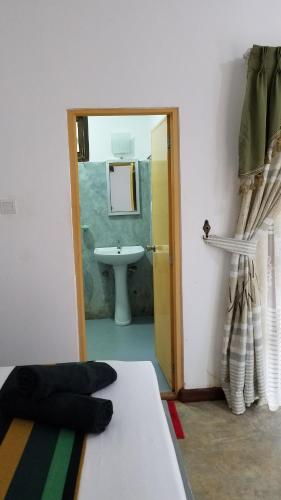 锡吉里亚Sigiri Holiday Villa的客房设有床、水槽和镜子