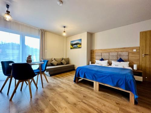 卡尔帕奇Apartamenty Pruskie的一间卧室配有一张床、一张桌子和一张沙发