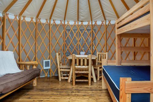 OceanviewLong beach Camping Resort Yurt 9的蒙古包内带一张床和一张桌子的房间