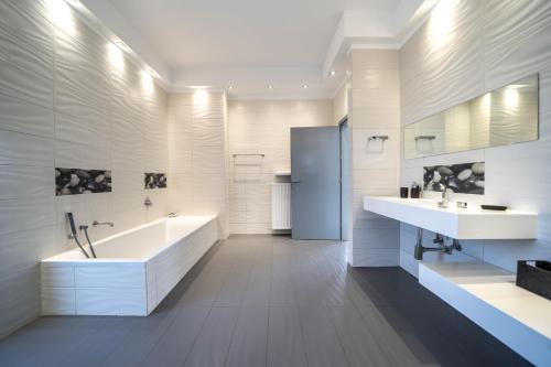 VarípetronLa Maison Du Soleil的白色的浴室设有2个水槽、浴缸和浴缸。
