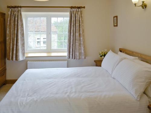 Buckland DinhamDippers Folly的卧室配有白色的床和窗户。