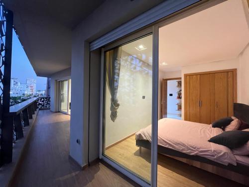 卡萨布兰卡Luxury Apart 2 CH -CASA FINANCE CITY的一间卧室设有大玻璃窗和一张床