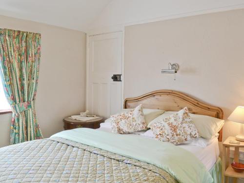 韦斯特尔顿希思维尤乡村别墅的卧室配有带枕头的床铺和窗户。