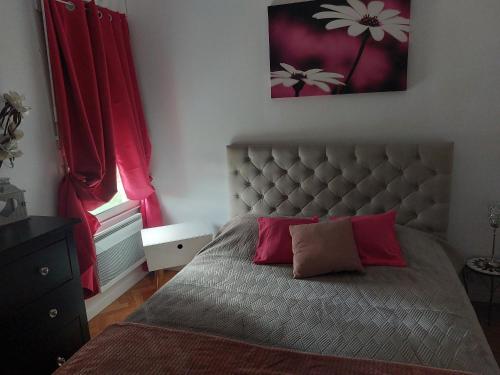 图卢兹Chez mimi的一间卧室配有一张带红色窗帘的大床