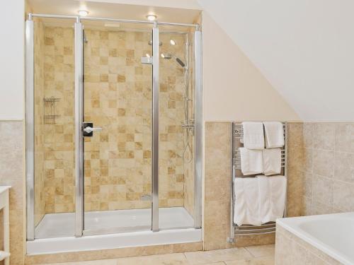 Colyton斯托汉姆乡村别墅的浴室里设有玻璃门淋浴