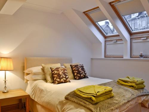 罗撒西Bruichladdich的一间卧室设有一张床和两个窗户。