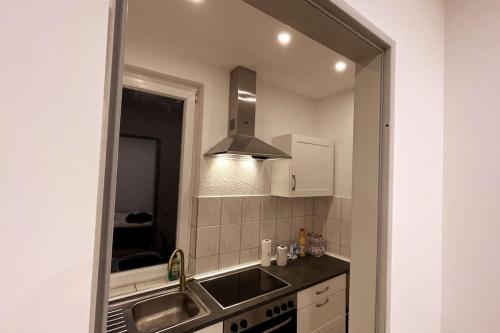 汉堡Dein Apartment的厨房配有水槽和大镜子