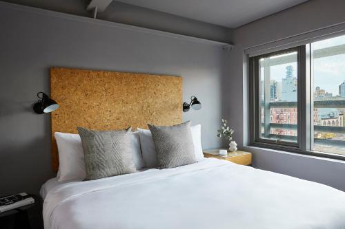 纽约Kasa Lantern Lower East Side的卧室设有一张白色大床和一扇窗户。