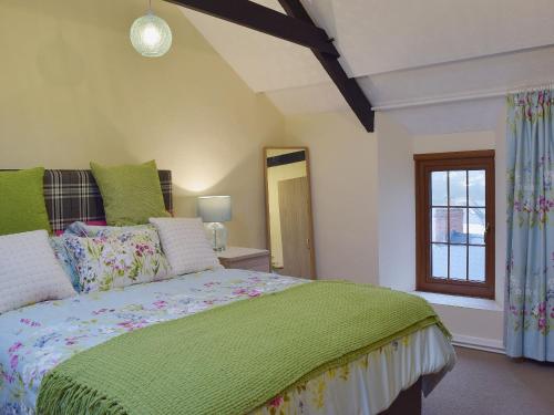 卡迪根Ty Capel Seion的一间卧室设有一张绿色的床和一个窗户。
