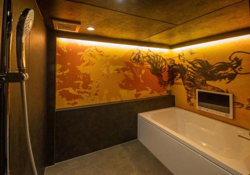 姬路Hotel Kaguya的带浴缸的浴室和墙上的绘画