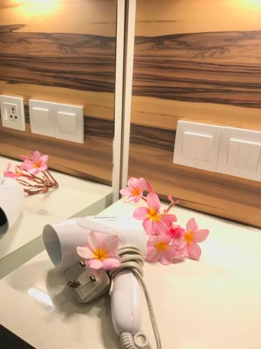 珍南海滩阿巴迪别墅度假酒店的白色的器具,在柜台上摆放着粉红色的花朵